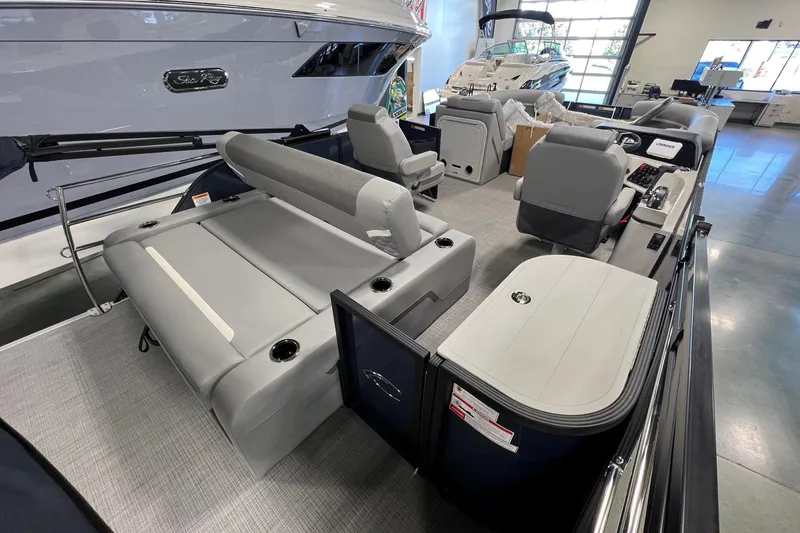 Slide: The Image of 2026 Crest Conquest 230 SLSC pontoon boat interior with gray seating and modern dashboard. - 9