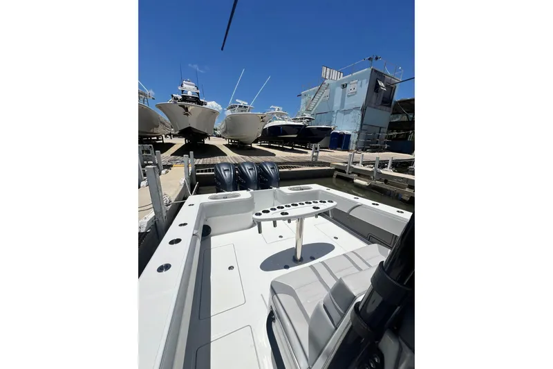 Slide: The Image of 2013 SeaHunter 39 Tournament boat docked, featuring spacious deck and multiple outboard engines. - 3