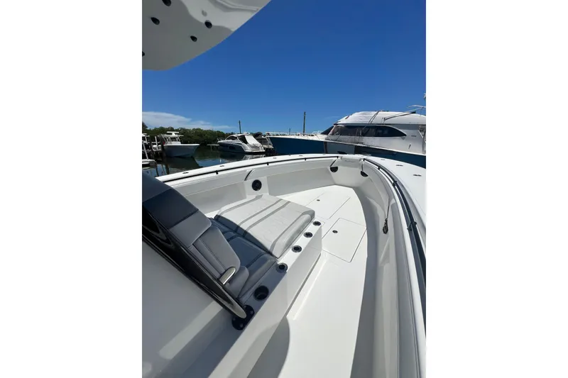 Slide: The Image of 2013 SeaHunter 39 Tournament boat interior with seating, docked in a marina under clear blue sky. - 4