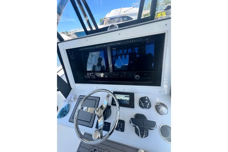 Slide: The Image of Control panel of 2013 SeaHunter 39 Tournament boat with steering wheel and navigation screens. - 7