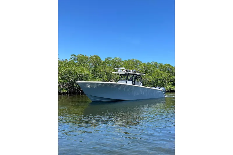 Slide: The Image of 2013 SeaHunter 39 Tournament boat on calm water, surrounded by lush greenery. - 8