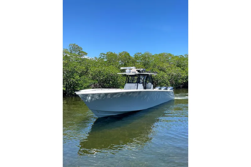 Slide: The Image of 2013 SeaHunter 39 Tournament boat on calm water, surrounded by lush greenery. - 9