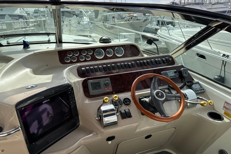 Slide: The Image of 1999 Sea Ray Sundancer 400 helm with wooden steering wheel and navigation instruments. - 12