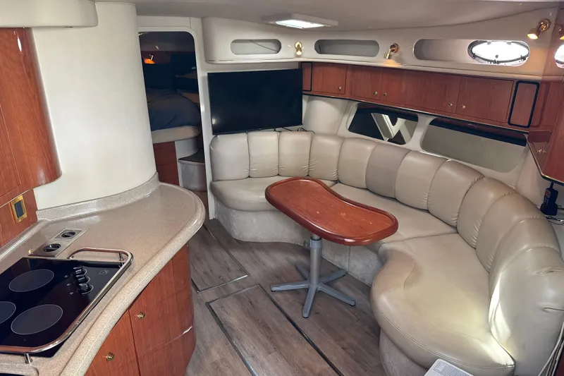 Slide: The Image of 1999 Sea Ray Sundancer 400 interior with leather seating, wooden table, and kitchenette. - 16