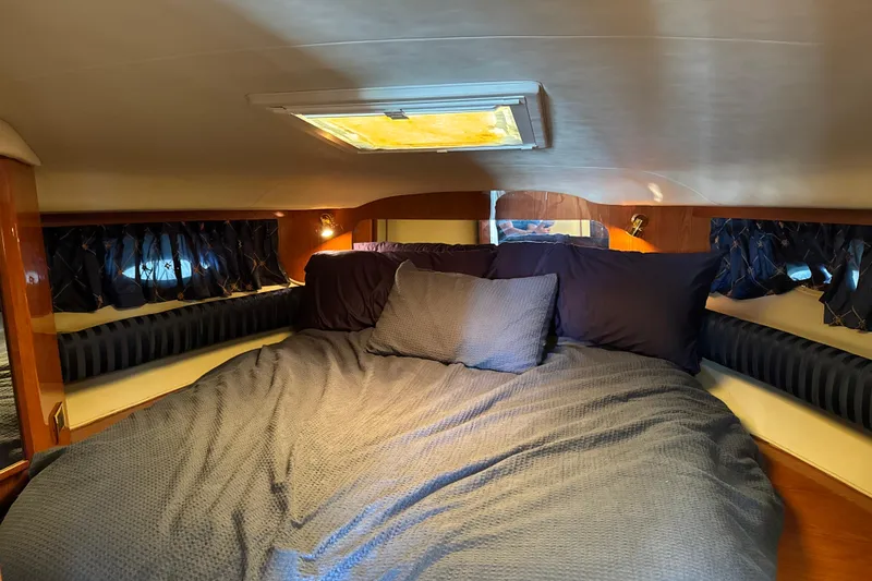 Slide: The Image of Cozy cabin interior of 1999 Sea Ray Sundancer 400 with plush bedding and ambient lighting. - 18