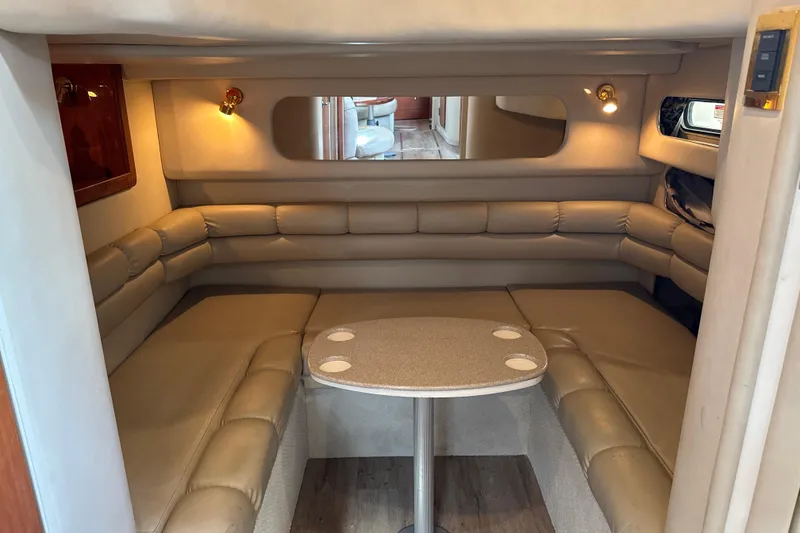 Slide: The Image of 1999 Sea Ray Sundancer 400 interior with beige leather seating and compact dining table. - 20
