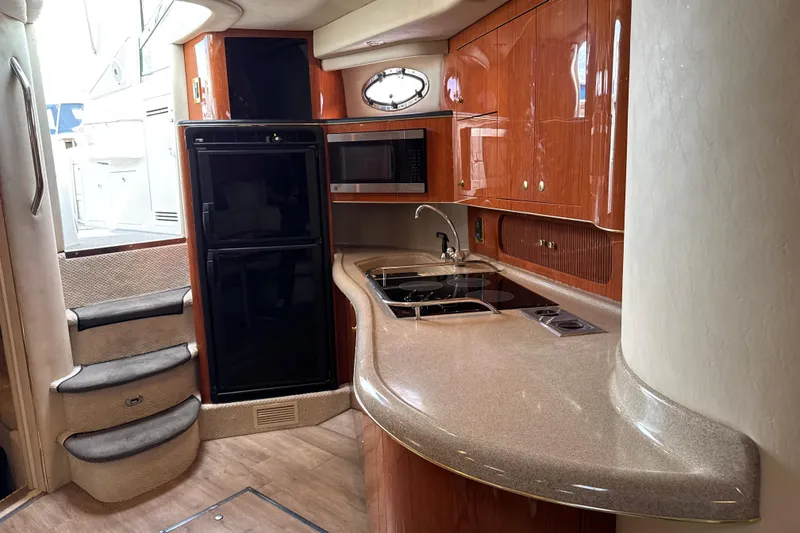 Slide: The Image of Luxurious 1999 Sea Ray Sundancer 400 yacht kitchen with modern appliances and elegant wood cabinetry. - 25