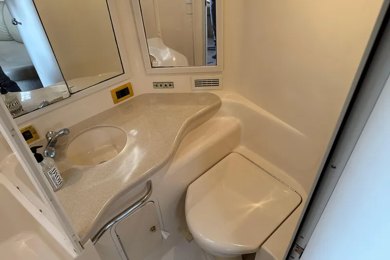 Slide: The Image of 1999 Sea Ray Sundancer 400 bathroom with sink, mirror, and toilet in compact design. - 26