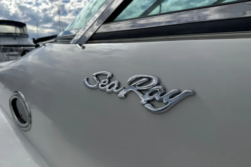 Slide: The Image of 1999 Sea Ray Sundancer 400 boat with logo, docked under cloudy sky. - 5