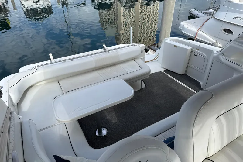 Slide: The Image of 1999 Sea Ray Sundancer 400 yacht interior with white seating and table, docked at marina. - 9