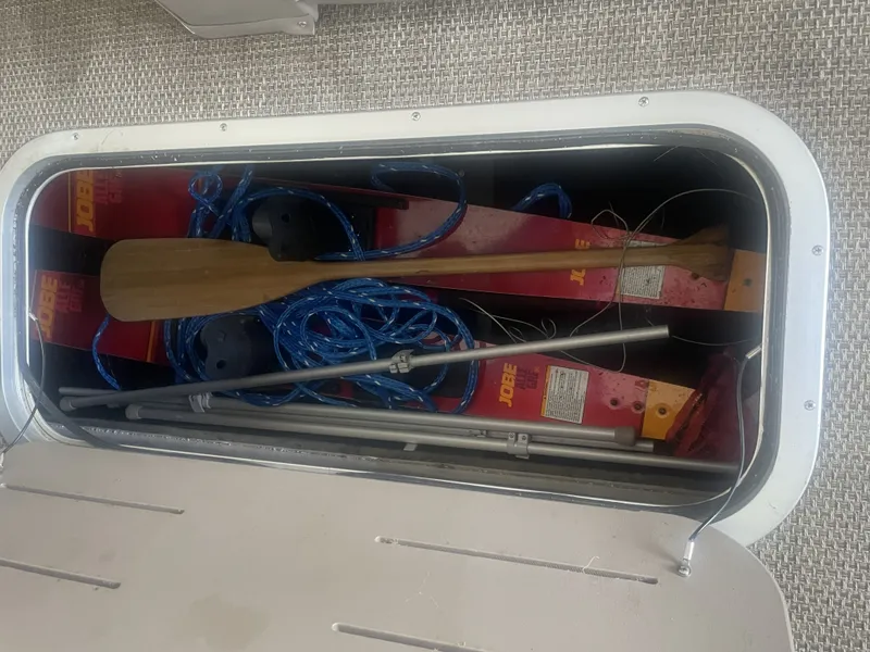 Slide: The Image of Storage compartment in a 2020 Bennington SSRFBXP boat with paddles and ropes. - 14