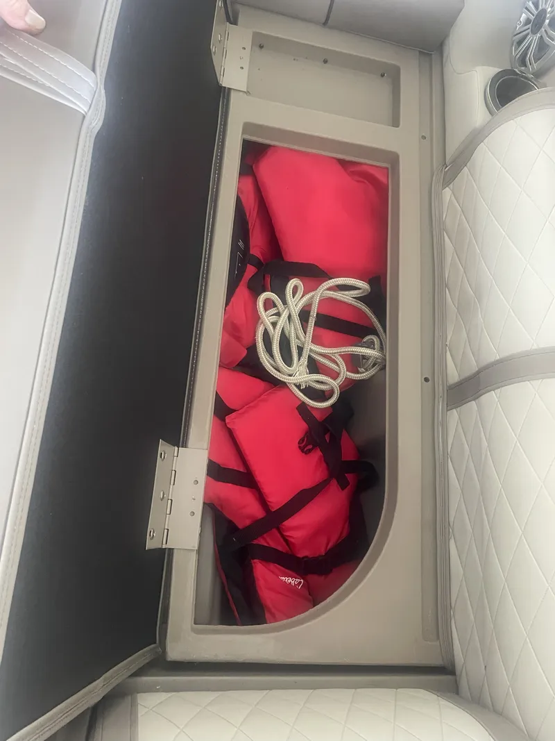 Slide: The Image of Storage compartment in a 2020 Bennington ssrfbxp boat with red life jackets and rope. - 15
