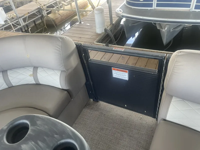 Slide: The Image of 2020 Bennington SSRFBXP pontoon boat interior with seating and safety gate at dock. - 26