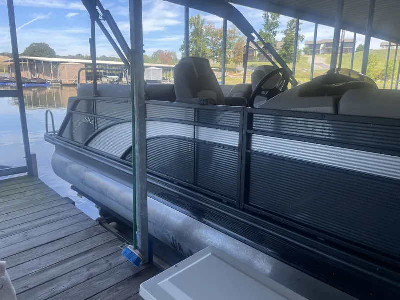 Slide: The Image of 2020 Bennington SSRFBXP pontoon boat docked on a calm lake under a covered slip. - 37