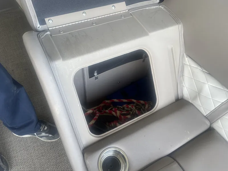 Slide: The Image of Open storage compartment in 2020 Bennington SSRFBXP boat with cup holder and rope inside. - 8