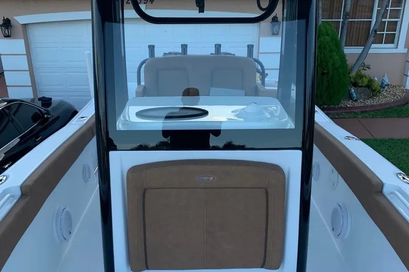 Slide: The Image of 2022 Sea Hunt Gamefish 25 boat interior with console and seating, parked in driveway. - 15