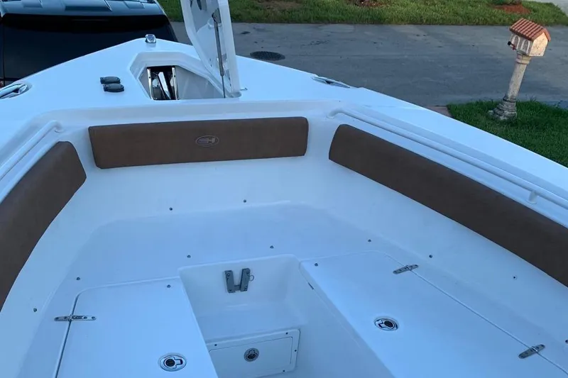 Slide: The Image of 2022 Sea Hunt Gamefish 25 boat interior with cushioned seating and storage compartments. - 17