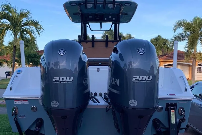 Slide: The Image of 2022 Sea Hunt Gamefish 25 boat on trailer, parked near palm trees at sunset. - 21
