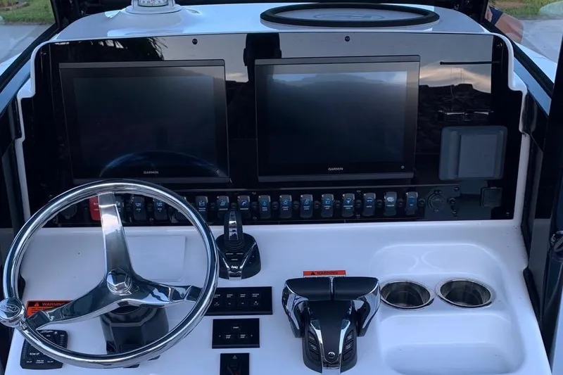 Slide: The Image of 2022 Sea Hunt Gamefish 25 dashboard with dual Garmin screens and steering wheel. - 6