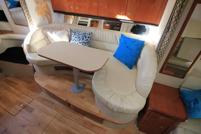 Slide: The Image of Interior of 2000 Sea Ray 340 Sundancer with cozy seating and wooden accents. - 10