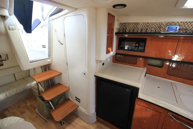 Slide: The Image of Interior of 2000 Sea Ray 340 Sundancer yacht with kitchenette and wooden steps. - 20