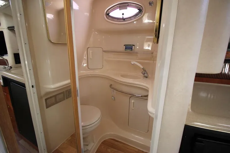 Slide: The Image of 2000 Sea Ray 340 Sundancer bathroom with compact design, sink, and porthole window. - 22