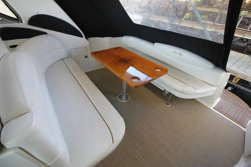 Slide: The Image of Interior of 2000 Sea Ray 340 Sundancer with white seating and wooden table. - 3