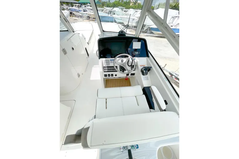 Slide: The Image of 2021 World Cat 325 DC boat interior with steering wheel and control panel. - 3