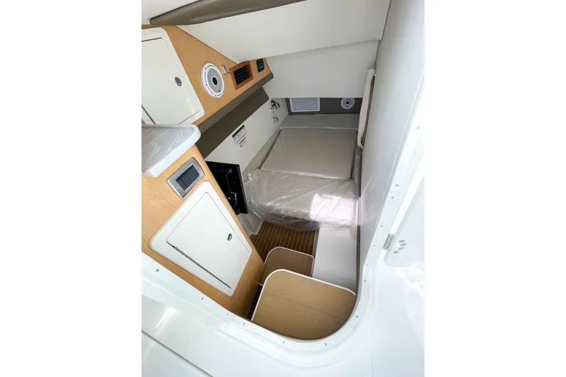 Slide: The Image of 2021 World Cat 325 DC cabin interior with bed, storage, and wood accents. - 4