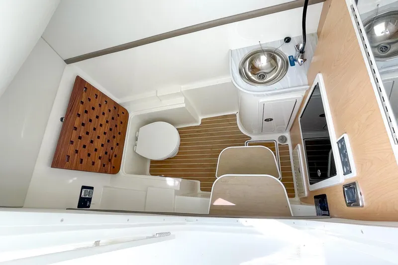 Slide: The Image of 2021 World Cat 325 DC boat interior with sink, toilet, and wooden flooring. - 5