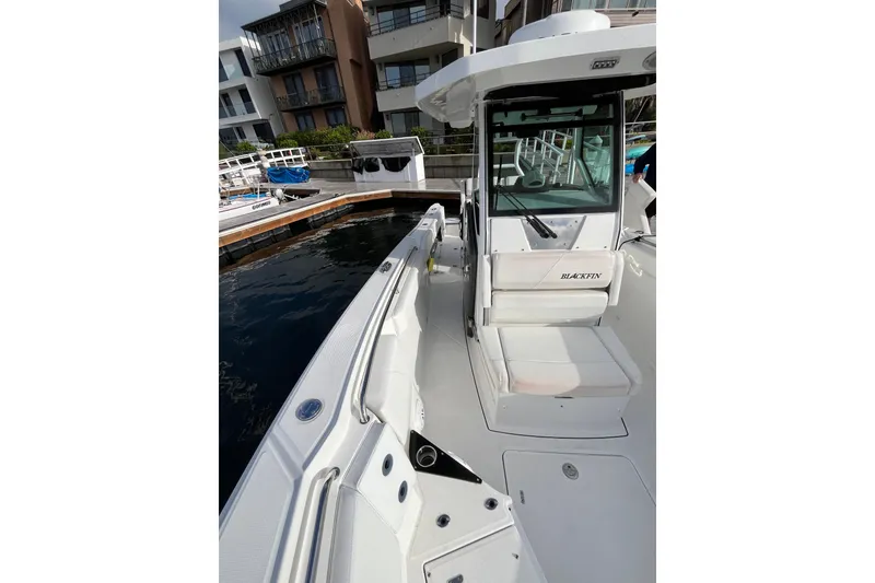 Slide: The Image of 2019 Blackfin 272 CC boat docked near modern buildings. - 12