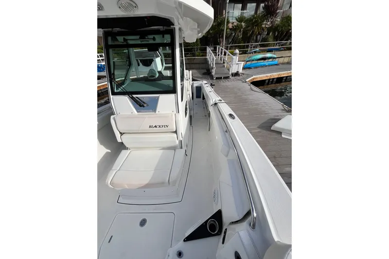 Slide: The Image of 2019 Blackfin 272 CC boat docked, showcasing sleek design and spacious deck. - 13