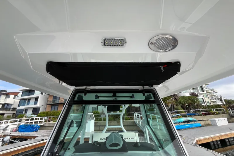Slide: The Image of 2019 Blackfin 272 CC boat interior, featuring helm station and overhead storage. - 25