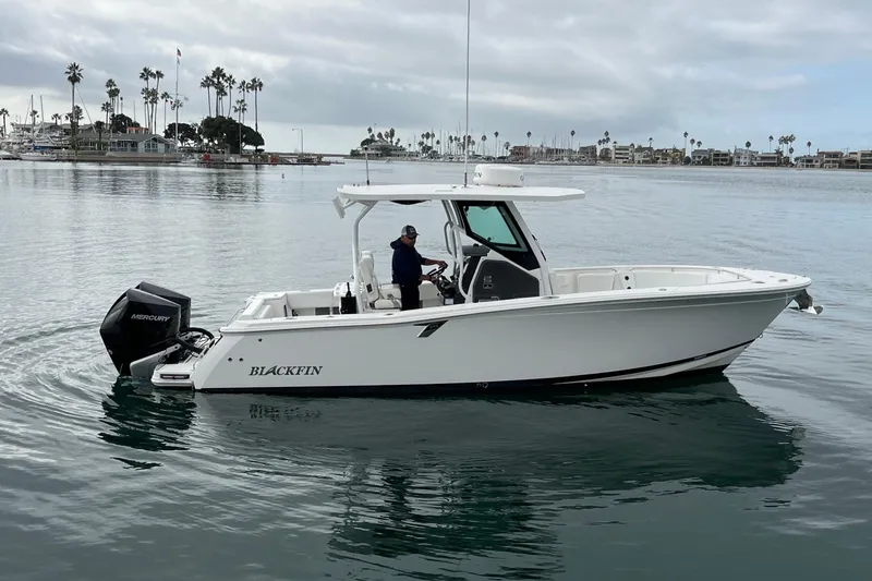Slide: The Image of 2019 Blackfin 272 CC boat on calm water with palm trees in the background. - 3
