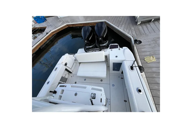 Slide: The Image of 2019 Blackfin 272 CC boat docked, featuring dual outboard motors and spacious seating area. - 32
