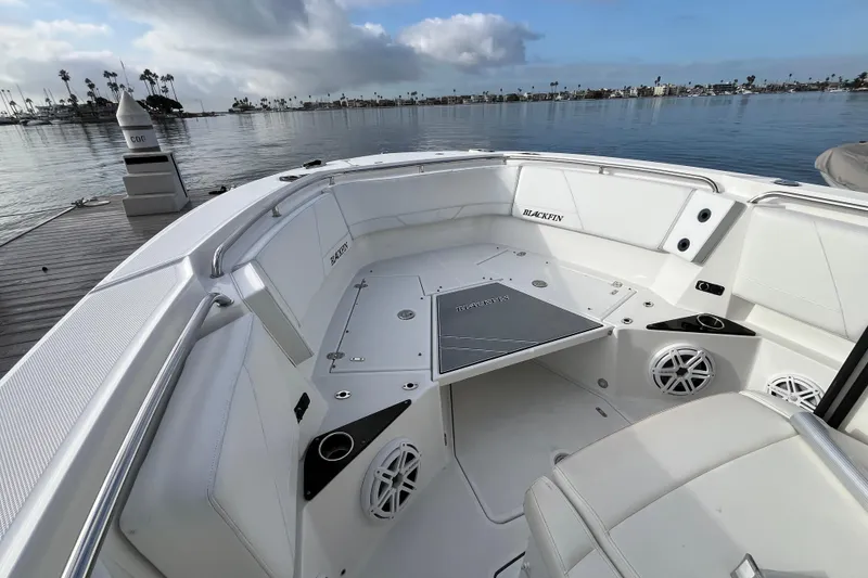 Slide: The Image of 2019 Blackfin 272 CC boat interior with white seating, docked by calm waters. - 8