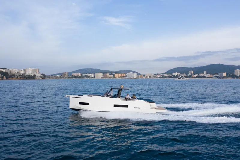 Slide: The Image of 2026 De Antonio Yachts 50 Open cruising on a scenic coastal waterway. - 2