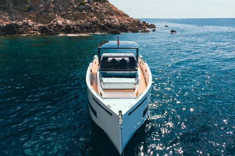 Slide: The Image of 2026 De Antonio Yachts 50 Open on clear blue water near rocky coastline. - 9