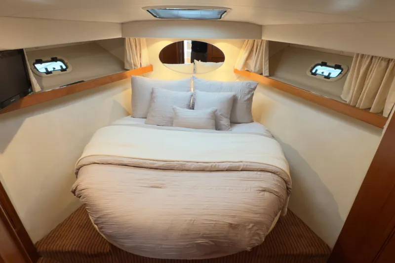 Slide: The Image of Luxurious cabin interior of 2001 Riviera Twin Cabin Convertible yacht with cozy bedding. - 2