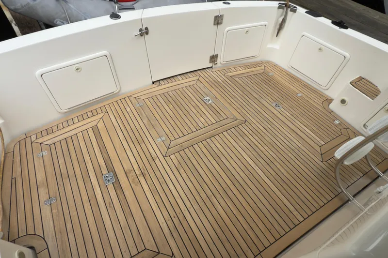 Slide: The Image of Teak deck of 2001 Riviera Twin Cabin Convertible boat, featuring storage hatches and clean design. - 25