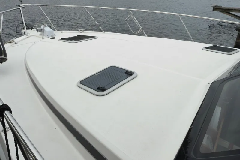 Slide: The Image of 2001 Riviera Twin Cabin Convertible yacht deck with hatches, docked by the water. - 29