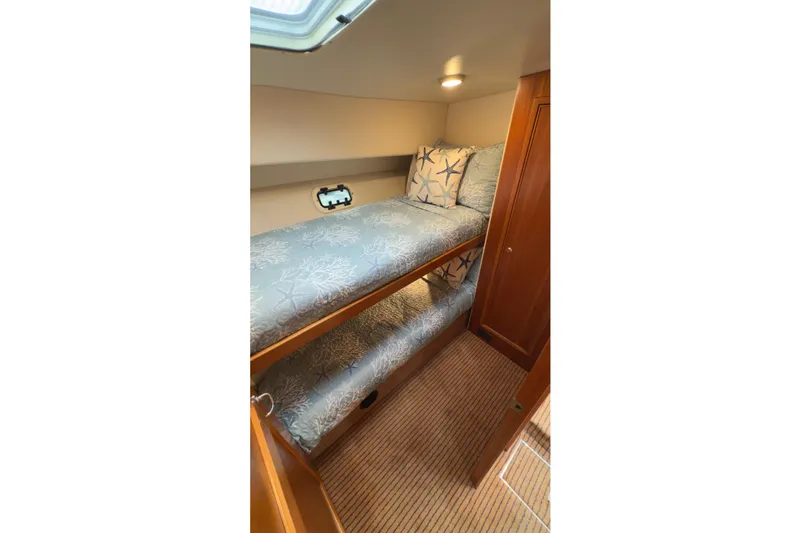 Slide: The Image of 2001 Riviera Twin Cabin Convertible with cozy bunk beds and nautical-themed bedding. - 3