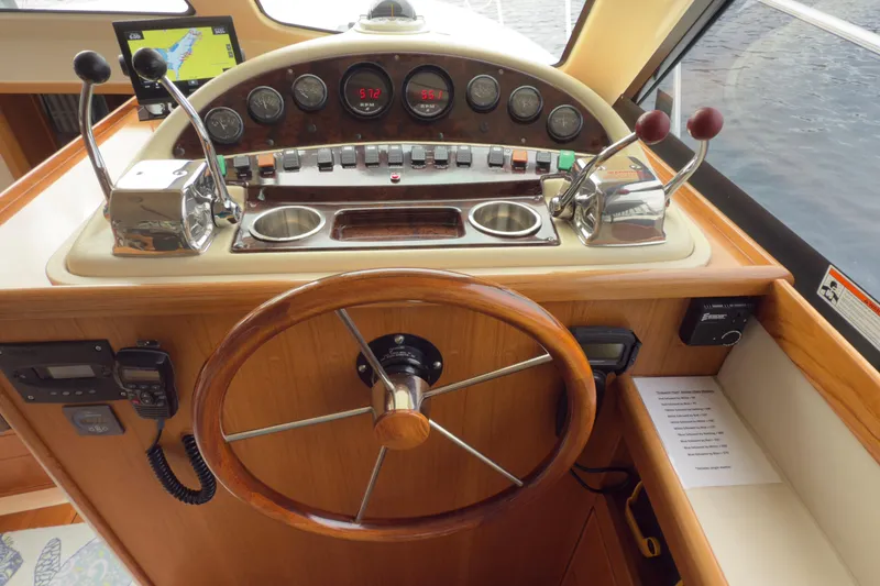 Slide: The Image of 2001 Riviera Twin Cabin Convertible boat helm with wooden steering wheel and control panel. - 4