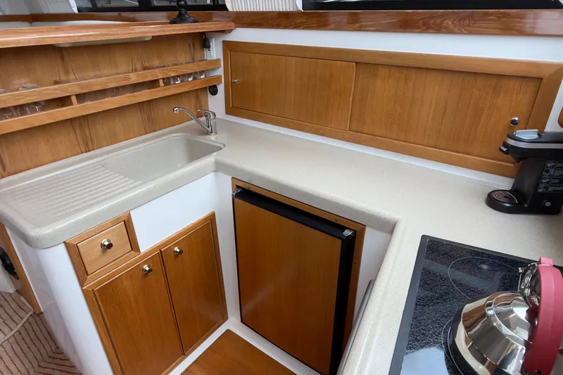 Slide: The Image of 2001 Riviera Twin Cabin Convertible yacht kitchen with wooden cabinets and modern appliances. - 6