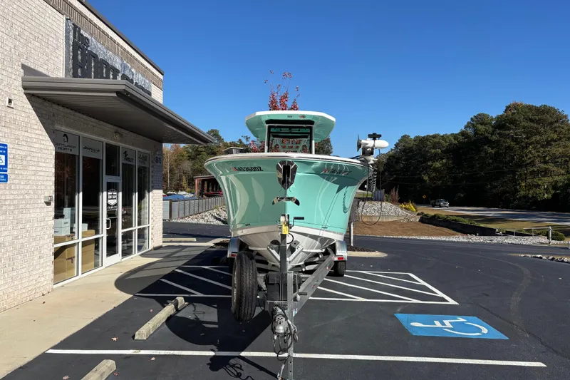 Slide: The Image of 2023 Blackfin 272CC boat on trailer outside dealership, clear sky, parking lot. - 1