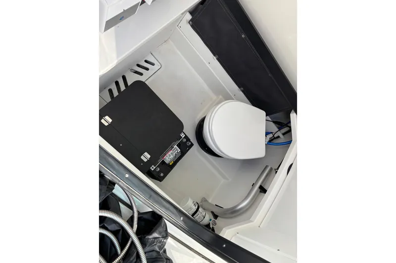 Slide: The Image of 2023 Blackfin 272CC boat interior with compact marine toilet setup. - 11
