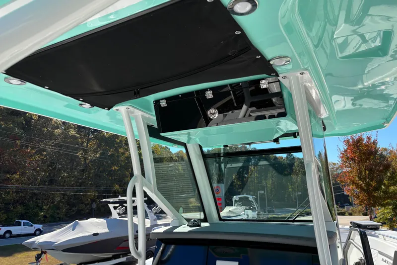 Slide: The Image of 2023 Blackfin 272CC boat interior with teal accents and overhead storage. - 17