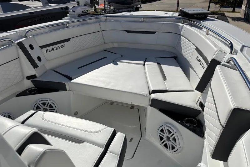 Slide: The Image of 2023 Blackfin 272CC boat interior with white cushioned seating and speaker system. - 4
