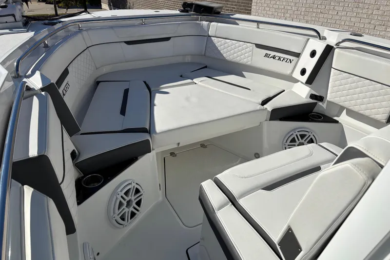 Slide: The Image of 2023 Blackfin 272CC boat interior with white cushioned seating and speaker system. - 5
