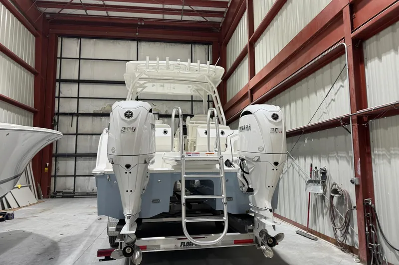 Slide: The Image of 2026 World Cat 265 DC-X boat with dual Yamaha engines in a storage facility. - 4